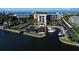 Aerial view of a marina, condos, and waterfront property with lush landscaping and boat docks at 5855 Midnight Pass Rd # 303, Sarasota, FL 34242