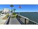 Dock and water view with greenery and American flag at 5855 Midnight Pass Rd # 303, Sarasota, FL 34242