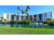 Beautiful exterior view of the condo building with lush landscaping and a serene waterfront feature at 5855 Midnight Pass Rd # 303, Sarasota, FL 34242