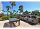 Outdoor grilling area with multiple gas grills, table, and nearby pool area at 5855 Midnight Pass Rd # 303, Sarasota, FL 34242