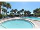 Resort-style pool and lounge area with chairs surrounded by lush landscaping and a multi-story building at 5855 Midnight Pass Rd # 303, Sarasota, FL 34242