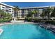 Resort-style pool and lounge area with chairs surrounded by lush landscaping and a multi-story building at 5855 Midnight Pass Rd # 303, Sarasota, FL 34242