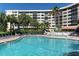 Resort-style pool and lounge area with chairs surrounded by lush landscaping and a multi-story building at 5855 Midnight Pass Rd # 303, Sarasota, FL 34242