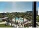 Screened view of community pools, landscaping, and nearby buildings at 5855 Midnight Pass Rd # 303, Sarasota, FL 34242