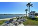 Benches and lounge chairs along the waterfront with gazebo, palm trees, and scenic view at 5855 Midnight Pass Rd # 303, Sarasota, FL 34242