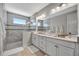 A luxurious bathroom featuring a glass-enclosed shower and double vanity sink at 6027 White Mangrove Ln, Bradenton, FL 34210
