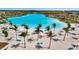A sandy beach with palm trees overlooking a clear turquoise lake at 6027 White Mangrove Ln, Bradenton, FL 34210
