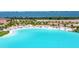A sandy beach with palm trees overlooking a large turquoise lake at 6027 White Mangrove Ln, Bradenton, FL 34210
