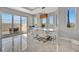 Elegant dining room with a marble table, white chairs, a decorative chandelier and ample natural light at 6027 White Mangrove Ln, Bradenton, FL 34210
