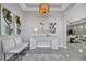 Modern entryway featuring white decor, gray tile flooring, a statement mirror and unique light fixture at 6027 White Mangrove Ln, Bradenton, FL 34210