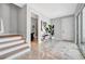 Welcoming foyer with modern finishes, tile flooring, staircase, and convenient access to a half bathroom at 6027 White Mangrove Ln, Bradenton, FL 34210