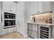 Well-equipped kitchen area with built-in oven, wine cooler, and sleek white cabinetry at 6027 White Mangrove Ln, Bradenton, FL 34210