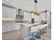 Stylish kitchen featuring white cabinetry, marble countertops, stainless steel appliances, and island seating at 6027 White Mangrove Ln, Bradenton, FL 34210