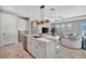 Modern kitchen featuring a marble island with seating, pendant lighting, and stainless steel appliances at 6027 White Mangrove Ln, Bradenton, FL 34210