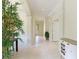 Bright hallway with tile flooring, decorative columns, and transom window over the front door at 6103 Aviary Ct, Bradenton, FL 34203