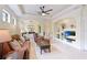Cozy living room with plush seating, a ceiling fan, and built-in shelving with a television at 6103 Aviary Ct, Bradenton, FL 34203