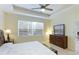 Bright main bedroom with tray ceiling, fan, and large window offering natural light at 6103 Aviary Ct, Bradenton, FL 34203