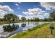 Scenic pond view reflecting the sky, surrounded by lush greenery and a golf course at 6103 Aviary Ct, Bradenton, FL 34203