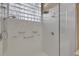Tiled shower room featuring a glass enclosure, shower heads, and a block glass window for added light at 612 Weston Pointe Ct, Longboat Key, FL 34228