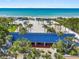 Aerial view of a beach club featuring a blue roof building, palm trees, and beach access at 612 Weston Pointe Ct, Longboat Key, FL 34228