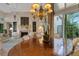 Elegant dining room with a large wooden table, chandelier, fireplace, and natural light from a sliding glass door at 612 Weston Pointe Ct, Longboat Key, FL 34228