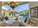 Elegant dining area with a large window overlooking a beautiful pool and patio at 612 Weston Pointe Ct, Longboat Key, FL 34228