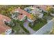 Aerial view of a residence featuring a pool, red tile roof, manicured lawns, and verdant landscaping at 612 Weston Pointe Ct, Longboat Key, FL 34228