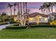 Charming front yard with lush lawn and manicured shrubbery and a beautiful home exterior at twilight at 612 Weston Pointe Ct, Longboat Key, FL 34228