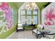 An airy sitting area features a tropical chandelier and bright pink floral artwork at 612 Weston Pointe Ct, Longboat Key, FL 34228