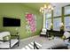 Airy seating area with vibrant green walls, eclectic chandelier, and ample natural light at 612 Weston Pointe Ct, Longboat Key, FL 34228