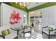 Green room with white trim, unique art, and seating with view of the outdoor area at 612 Weston Pointe Ct, Longboat Key, FL 34228