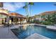 Inviting backyard pool with a bar area, lush landscaping, and an outdoor dining set at 612 Weston Pointe Ct, Longboat Key, FL 34228
