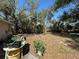 Large backyard featuring mature trees, offering ample space for outdoor activities at 6924 Tuxedo St, Englewood, FL 34224