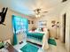 Bright bedroom boasts a ceiling fan, large window with curtains, and comfortable bed, creating a peaceful retreat at 6924 Tuxedo St, Englewood, FL 34224