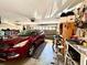 Garage area with a car, tools, storage, and a large garage door at 6924 Tuxedo St, Englewood, FL 34224