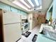 Kitchen featuring a vintage aesthetic with tile flooring, laminate countertops, and white appliances at 6924 Tuxedo St, Englewood, FL 34224