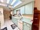 Functional kitchen with retro-mint cabinets, skylight and tile floors at 6924 Tuxedo St, Englewood, FL 34224