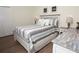 Neutral bedroom features a queen-sized bed with stylish bedding, side tables with lamps, and a closet at 7547 Campus Cv, Sarasota, FL 34243