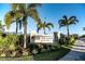 Welcoming entrance to University Village with lush landscaping and palm trees at 7547 Campus Cv, Sarasota, FL 34243