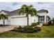 Charming single-story home featuring a two-car garage, landscaped yard, and decorative palms at 7547 Campus Cv, Sarasota, FL 34243