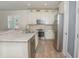 Modern kitchen featuring white cabinets, stainless steel appliances, granite countertops, and wood-look floors at 7547 Campus Cv, Sarasota, FL 34243