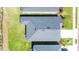 An aerial view displaying the roof of a house with a dark grey shingle roof and lush green lawn at 818 170Th E Ct, Bradenton, FL 34212