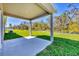 Covered back patio providing an outdoor living space with views of the green backyard and lush landscaping at 818 170Th E Ct, Bradenton, FL 34212