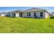 Backyard with lush green grass and covered patio. View of the rear exterior at 818 170Th E Ct, Bradenton, FL 34212