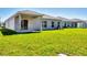Green backyard featuring lush grass and a covered patio with sliding glass doors at 818 170Th E Ct, Bradenton, FL 34212