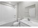 Clean bathroom with white tile, a tub, shower, and a modern vanity at 818 170Th E Ct, Bradenton, FL 34212