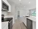 Modern kitchen features stainless steel appliances, quartz countertops and views into an open concept living space at 818 170Th E Ct, Bradenton, FL 34212