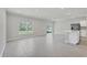 Open living area with tile floors, large windows and a modern kitchen in the background at 818 170Th E Ct, Bradenton, FL 34212