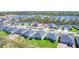 Aerial view showcasing a residential street with modern homes and green spaces in a developing community at 818 170Th E Ct, Bradenton, FL 34212