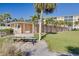 Exterior view of building with storage, manicured lawn, and palm trees, providing a well-maintained and inviting atmosphere at 8635 Midnight Pass Rd # 201C, Sarasota, FL 34242